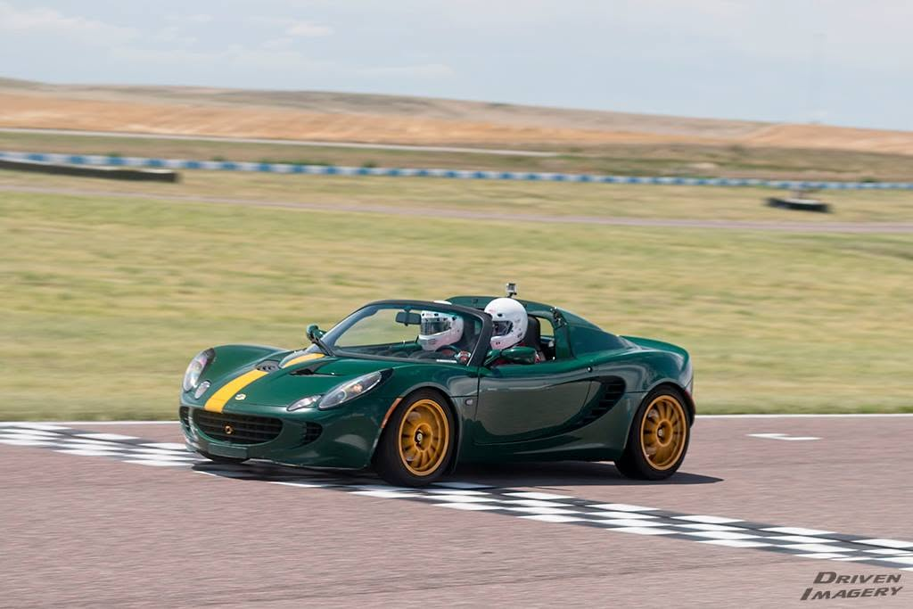 Dave Hill driving a green Lotus Elise on track.