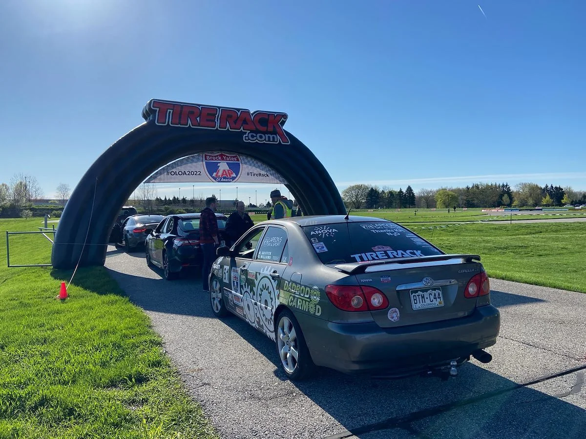Gray number 61 Dadbod Carmod Corolla staged near a track entry