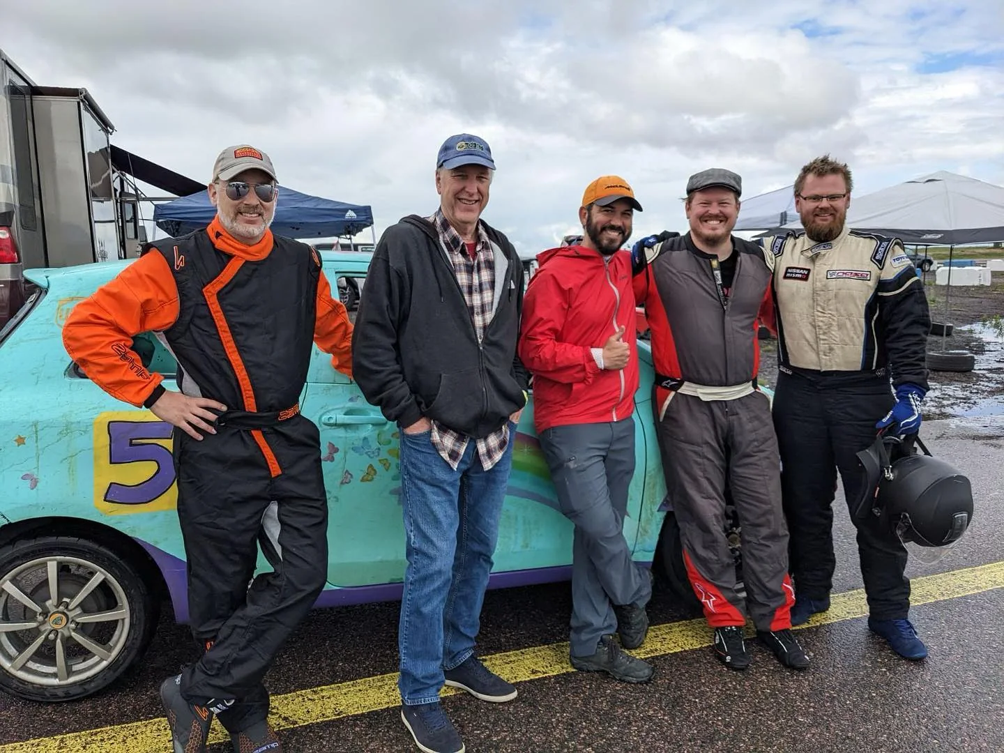 Dadbod Carmod crew members standing beside the turquoise number 57 Yaris