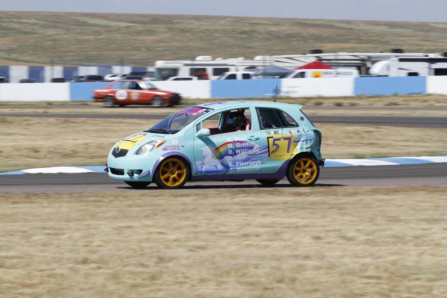 Turquoise number 57 Dadbod Carmod Yaris on a road course